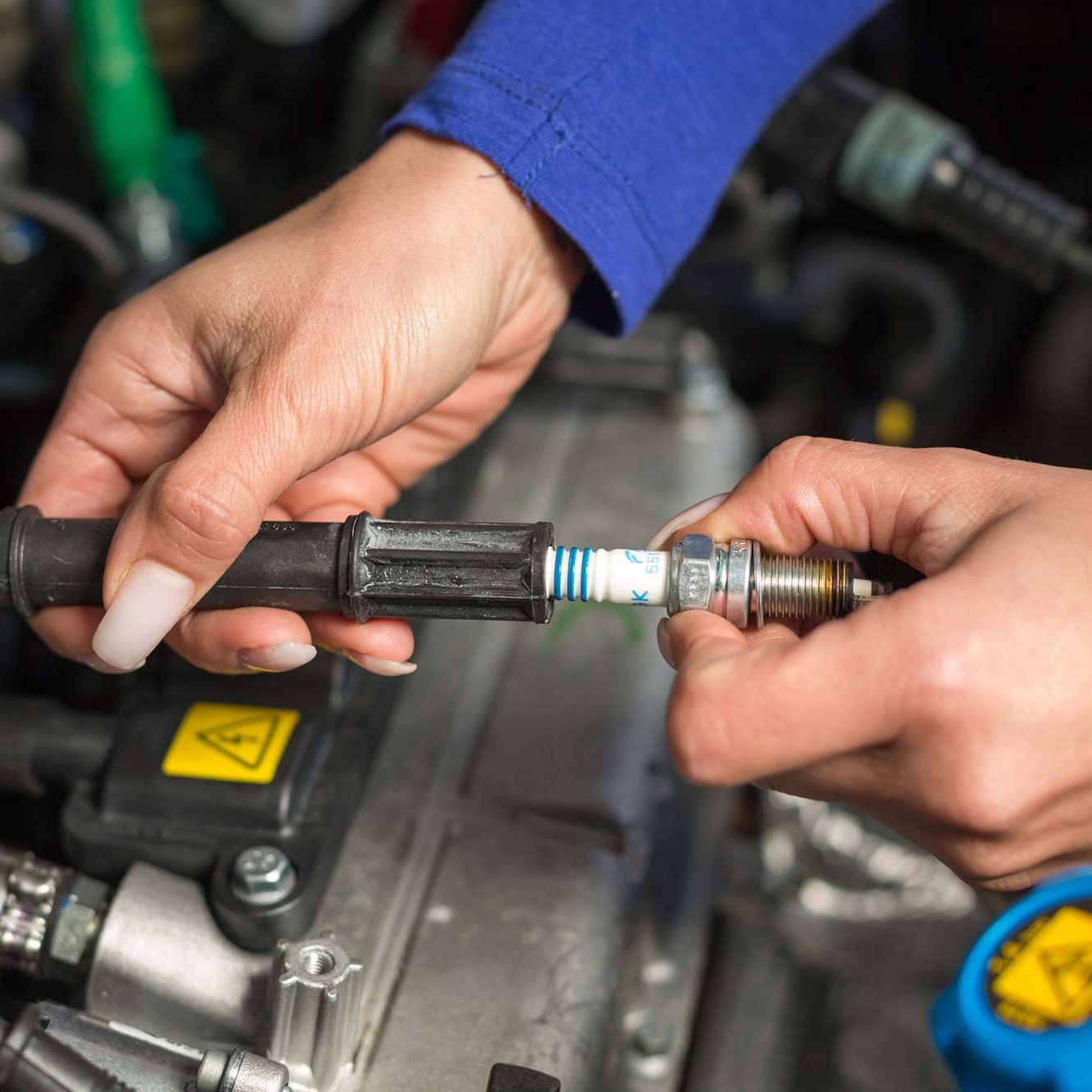 A car mechanic changing spark plugs